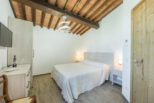 a bedroom with a bed and a desk and a tv at Il Poderino in Monteriggioni