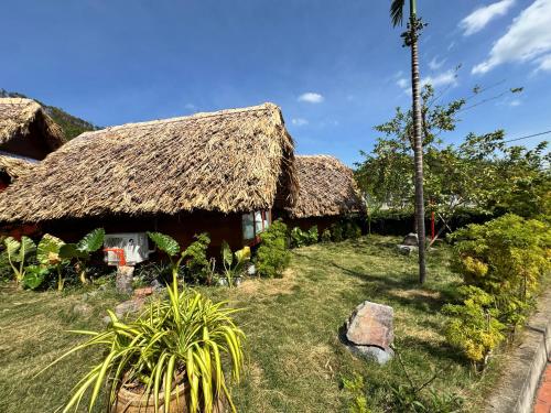 a group of huts with a grass roof at JoyStay in Cat Ba