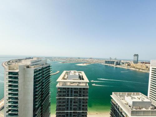 an aerial view of a body of water with buildings at Stunning Beachfront 1BR Apartment in Palm Jumeirah By ĀYA Boutique in Dubai