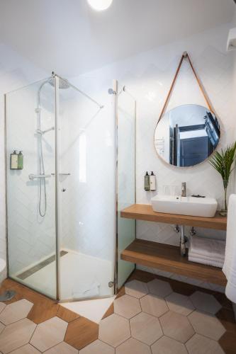 a bathroom with a shower with a sink and a mirror at Los Cardones Boutique Village in Playa de las Americas