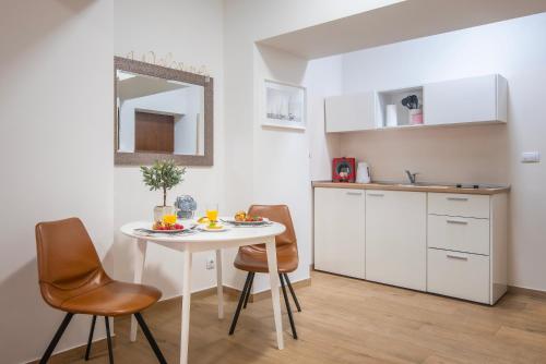 a small kitchen with a white table and chairs at D&A Amphitheatre Apartments with free parking in Pula