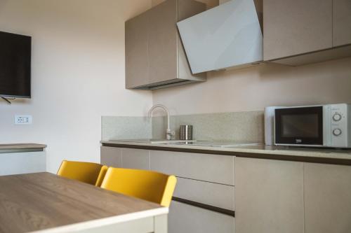 a kitchen with yellow chairs and a counter with a microwave at Villa Aris in Villa Gorizia