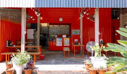 a restaurant with red walls and tables and potted plants at JoyStay in Cat Ba