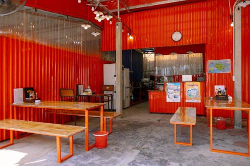 a restaurant with red walls and tables and a clock at JoyStay in Cat Ba