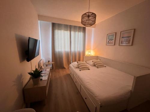 une chambre avec un grand lit et une télévision dans l'établissement L'escapade, studio avec vue mer, à Calais
