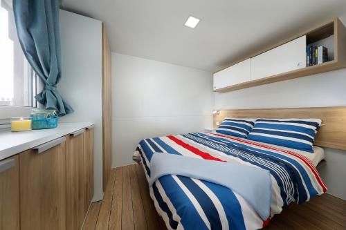 a small bedroom with a bed and a counter at Albatross Mobile Homes on Camping Bijela Uvala in Poreč