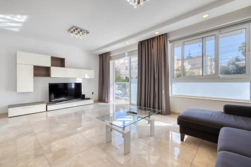 a living room with a couch and a glass table at St Georges Bay Oasis Steps from the Beach in St. Julianʼs