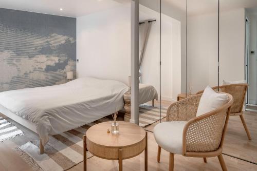 une chambre avec un lit, une chaise et une table dans l'établissement 200m de la plage - Grande maison pour 6 adultes et 2 enfants, à La Baule-les-Pins