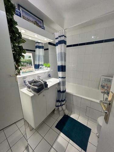 une salle de bain avec une baignoire, un lavabo et un miroir dans l'établissement Havre de Paix, à Paris