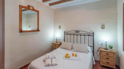 a bedroom with a bed with a mirror on the wall at Villazo II Almáchar by Ruralidays in Almáchar