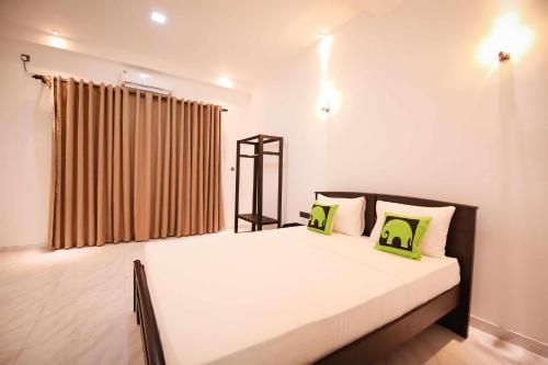 a bedroom with a large white bed with green pillows at Imon Lanka Beach Hotel in Matara