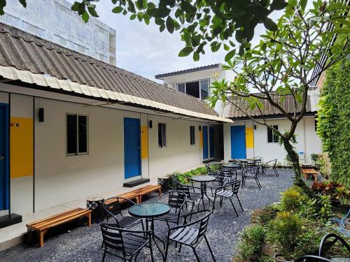a row of tables and chairs in a courtyard at RYB Hostel Phuket in Ban Lo Long