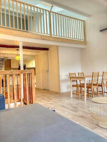 une chambre avec une table, des chaises et un escalier dans l'établissement Appartement de caractère, Lorgues, à Lorgues