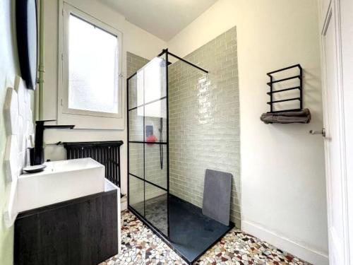 La salle de bains est pourvue d'une douche en verre et d'un lavabo blanc. dans l'établissement Le point carré - Smart & Cosy - Centre-Ville, à Troyes