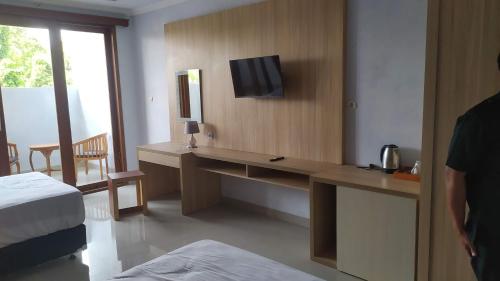 a hotel room with a desk with a television on it at Giri Kusuma Hotel Payangan in Payangan
