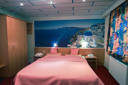 a bedroom with a pink bed with a painting on the wall at Hotel Strand-Café in Roßbach