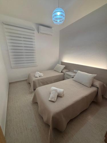 a bedroom with two beds and a blue light at El Descanso de Rocinante in Almagro