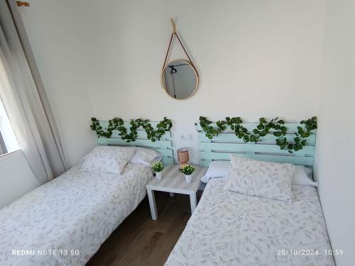 Un dormitorio con dos camas y una mesa con plantas. en Tierra y Mar, en Sanlúcar de Barrameda