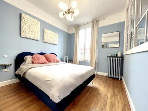 - une chambre avec des murs bleus et un lit avec des oreillers roses dans l'établissement Le point carré - Smart & Cosy - Centre-Ville, à Troyes