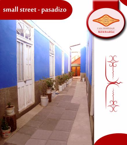 a small street with a blue building and a white door at Casona Moya in Arequipa
