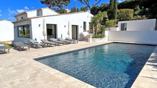 une piscine devant une maison blanche dans l'établissement Villa Les Geais, à Sainte-Maxime
