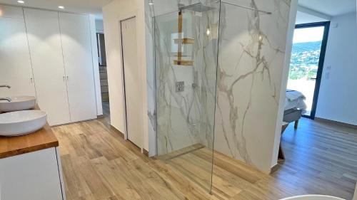 une salle de bain avec une douche en verre et un lavabo dans l'établissement Villa Les Geais, à Sainte-Maxime