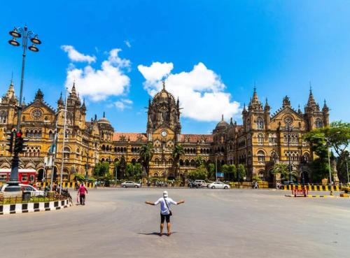 a man standing in front of a large building at YMCA Colaba Mumbai in Mumbai