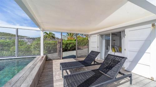 a balcony with two chairs and a swimming pool at Haven of peace villa in a perfect setting in Marigot