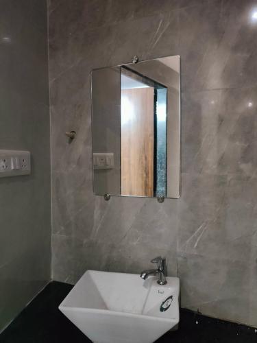 a bathroom with a sink and a mirror on the wall at Aafee cabin stay & dormitory in Mumbai