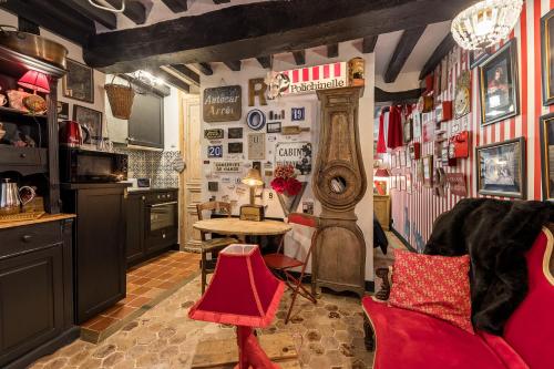 - une cuisine avec des chaises rouges et une table dans une chambre dans l'établissement Les Petites Suites Dieppoises - La Tanière du Loup, à Dieppe