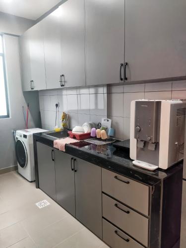 a kitchen with a counter top with a microwave at Kingfisher Sandakan in Sandakan