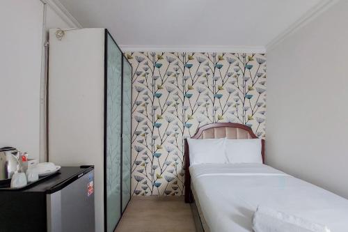 a bedroom with a bed and a wall at Affordable Studio No Kitchen Apartment at Aeropolis Residence near Soetta By Travelio in Tangerang