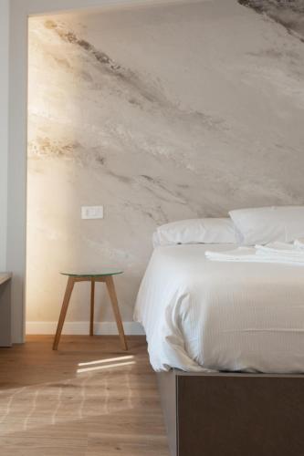 a bedroom with a white bed and a table at Albergo Panorama in Malesco