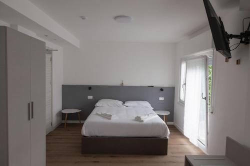 a bedroom with a white bed and two tables at Albergo Panorama in Malesco