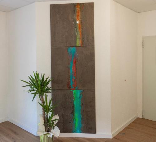 a painting on a wall in a room with a plant at Albergo Panorama in Malesco