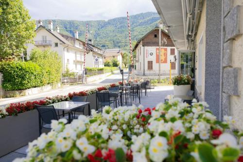 a restaurant with tables and chairs and flowers on a street at Albergo Panorama in Malesco