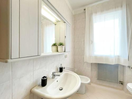 a white bathroom with a sink and a mirror at Al Belvedere in Zero Branco