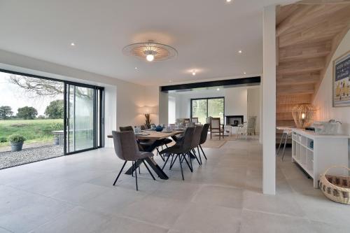 une salle à manger et une cuisine avec une table et des chaises dans l'établissement Kertromel - Grande maison pour 10, à Saint-Lormel