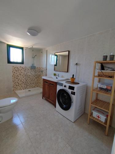 a bathroom with a washing machine and a sink at Vivienda Vacacional Casa del Erizo - Ecofinca in Nazaret