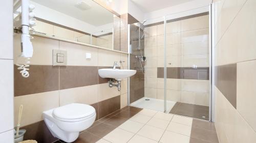 a bathroom with a toilet and a sink and a shower at Olympic Park I, Sun & Snow in Kołobrzeg