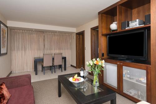 a living room with a couch and a television at Millennium Hotel & Resort Manuels Taupo in Taupo