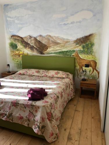 a bedroom with a bed with a painting on the wall at Nido D'Ape bed and breakfast in  Montepetra 
