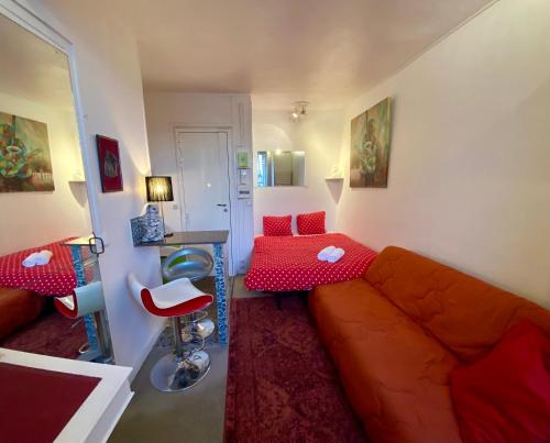 a living room with a couch and a table at Studio chic Paris Tour Eiffel Near Eiffel tower 7th floor in Paris