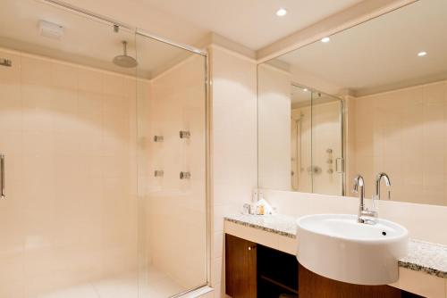 a bathroom with a sink and a shower at Millennium Hotel & Resort Manuels Taupo in Taupo