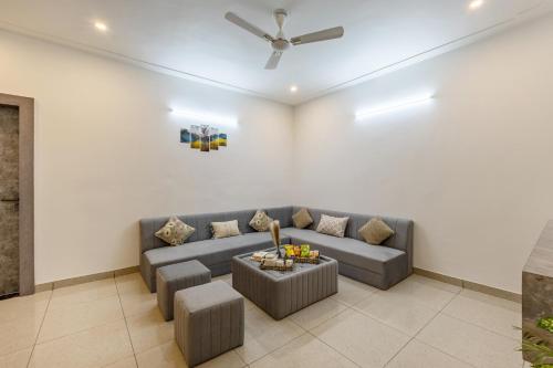 a living room with a couch and a table at Alaya Stays with Balcony & Hill View - Lake City Heights in Udaipur