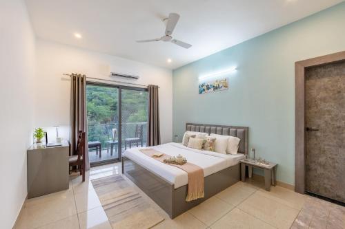 a bedroom with a large bed and a window at Alaya Stays with Balcony & Hill View - Lake City Heights in Udaipur