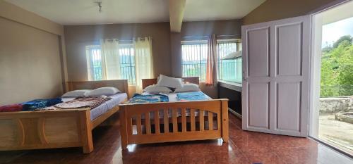 a bedroom with two beds and a window at Heath Cote in Ooty