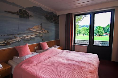 a bedroom with a bed and a large window at Hotel Strand-Café in Roßbach