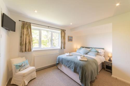 a bedroom with a bed and a window at Nursery Cottage in Ewhurst