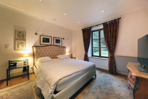 une chambre avec un grand lit et une télévision dans l'établissement L'Eau Vive - Une oase à 5 minutes de Gérardmer, à Gérardmer